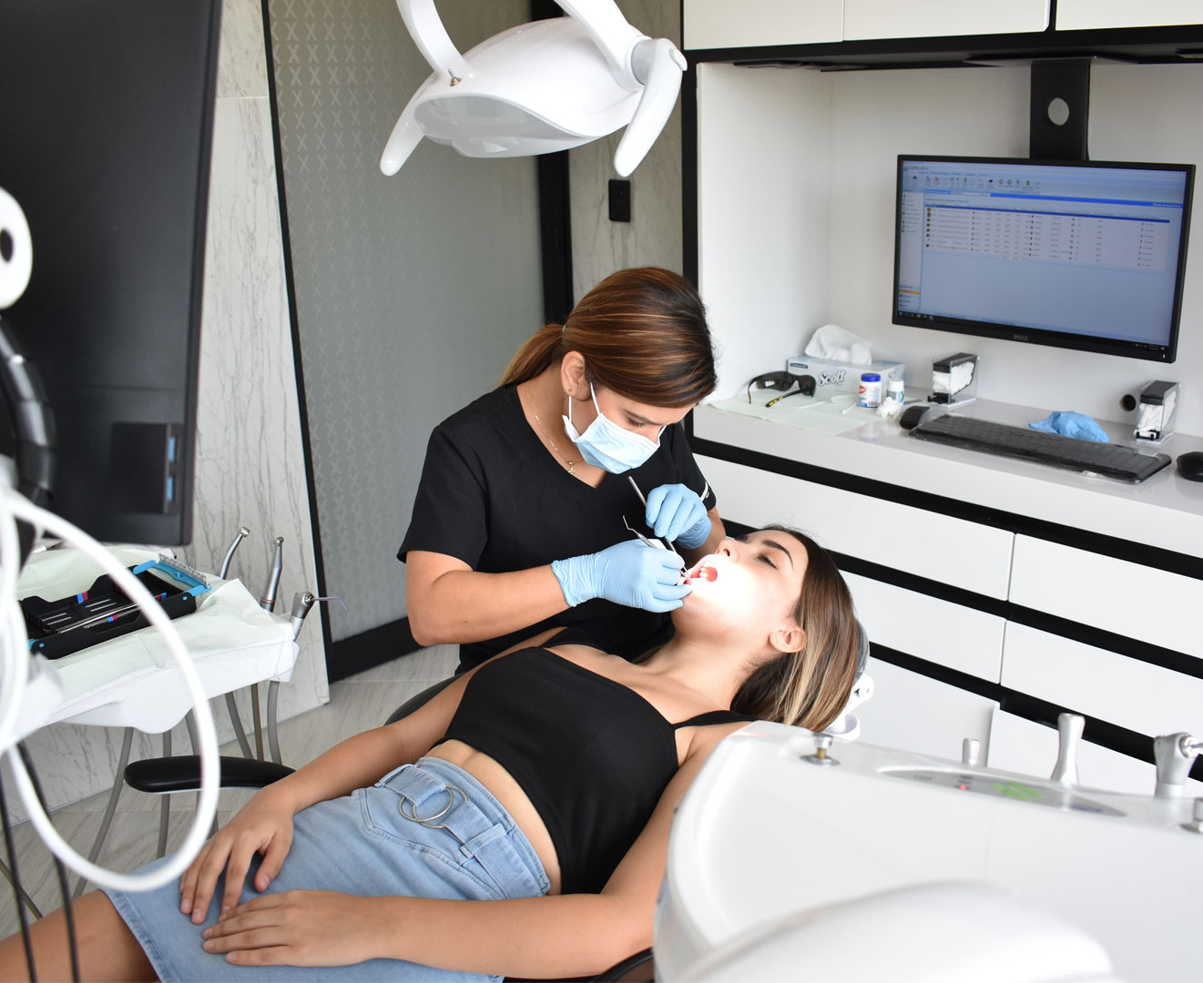 Imagen de odontóloga atendiendo a paciente en consultorio moderno, con equipos dentales de última generación