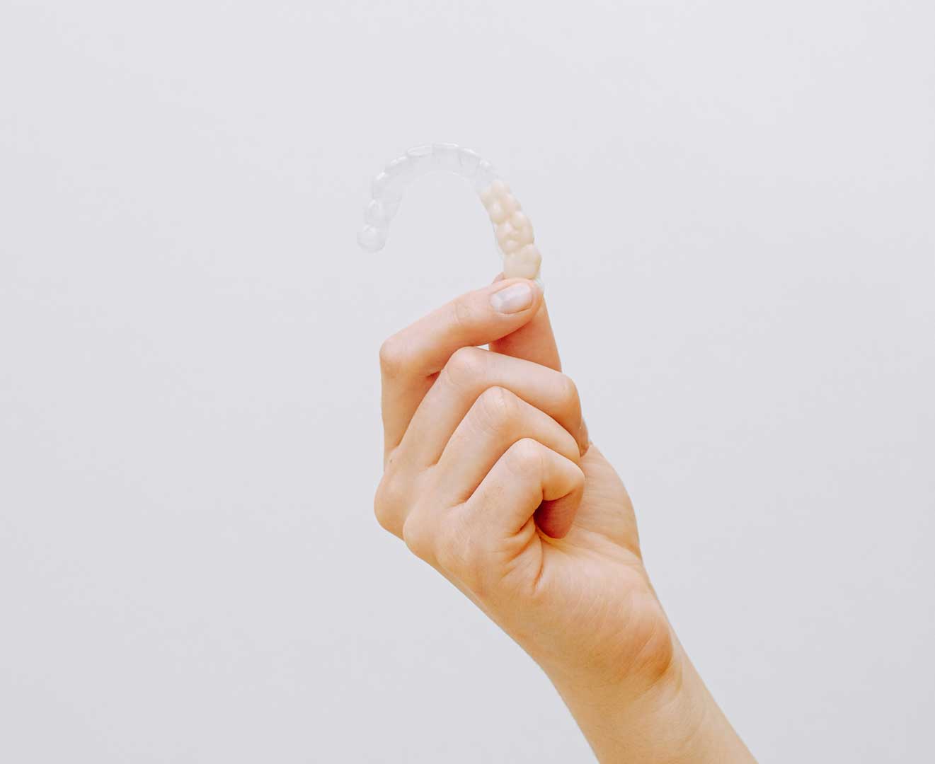 Imagen de una mano mostrando alineadores Invisalign, tecnología avanzada en ortodoncia invisible