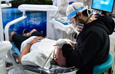 Imagen de dentista y asistente dental trabajando juntos en consultorio, aplicando protocolos de limpieza y atención profesional